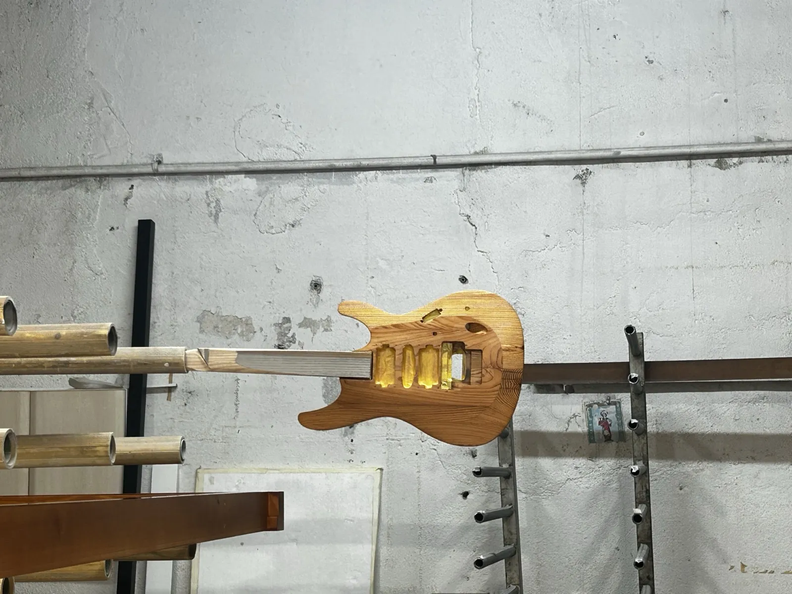 Cuerpo de guitarra de madera colgado para barnizar en el taller