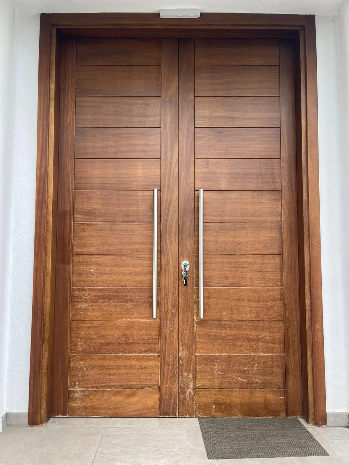 Puerta de madera con el barniz desgastado antes de restaurar