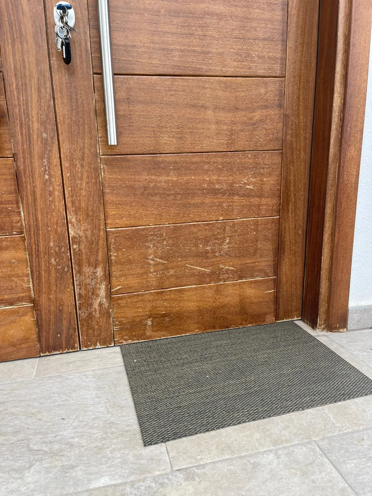Detalle del desgaste del barniz en la base de la puerta